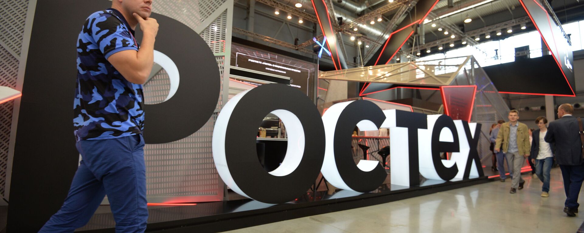 A visitor walks past Rostec's stand at the attends the Innoprom International Industrial Fair, in Yekaterinburg, Russia - Sputnik International, 1920, 12.08.2022