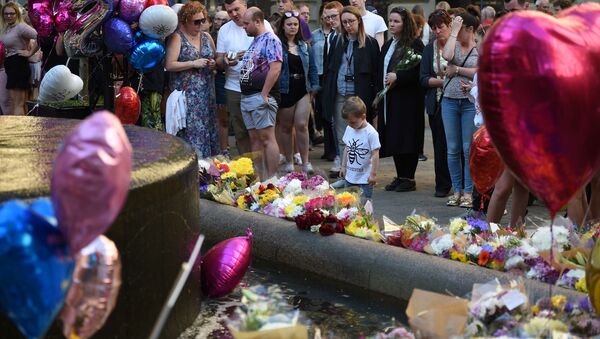 People pay their respects as they look at flowers and balloons left in central Manchester on May 22, 2018, the one year anniversary of the deadly attack at Manchester Arena.  - Sputnik International