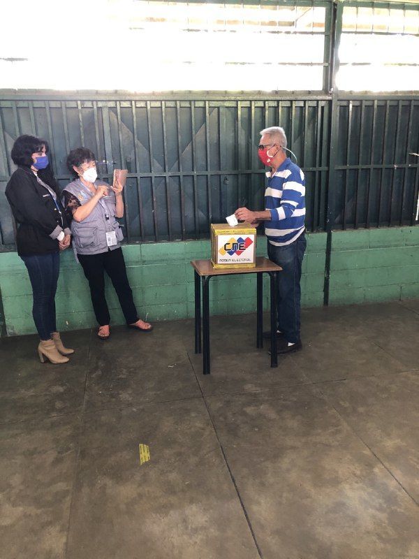 A woman takes a picture of a man casting his ballot at the parliamentary election in Venezuela, 6 December 2020. - Sputnik International