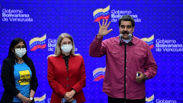 Venezuelan President Nicolas Maduro accompanied by his wife Cilia Flores (C) and Venezuela's Vice President Delcy Rodriguez (L) gestures while delivering a press conference at a polling station in the Simon Rodriguez school in Fuerte Tiuna, Caracas, on December 6, 2020 during Venezuela's legislative elections. - Sputnik International