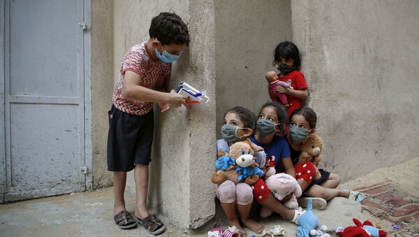 Palestinian children, mask-clad due to the Covid-19 coronavirus pandemic, play outside their house in Gaza City on 8 September - Sputnik International