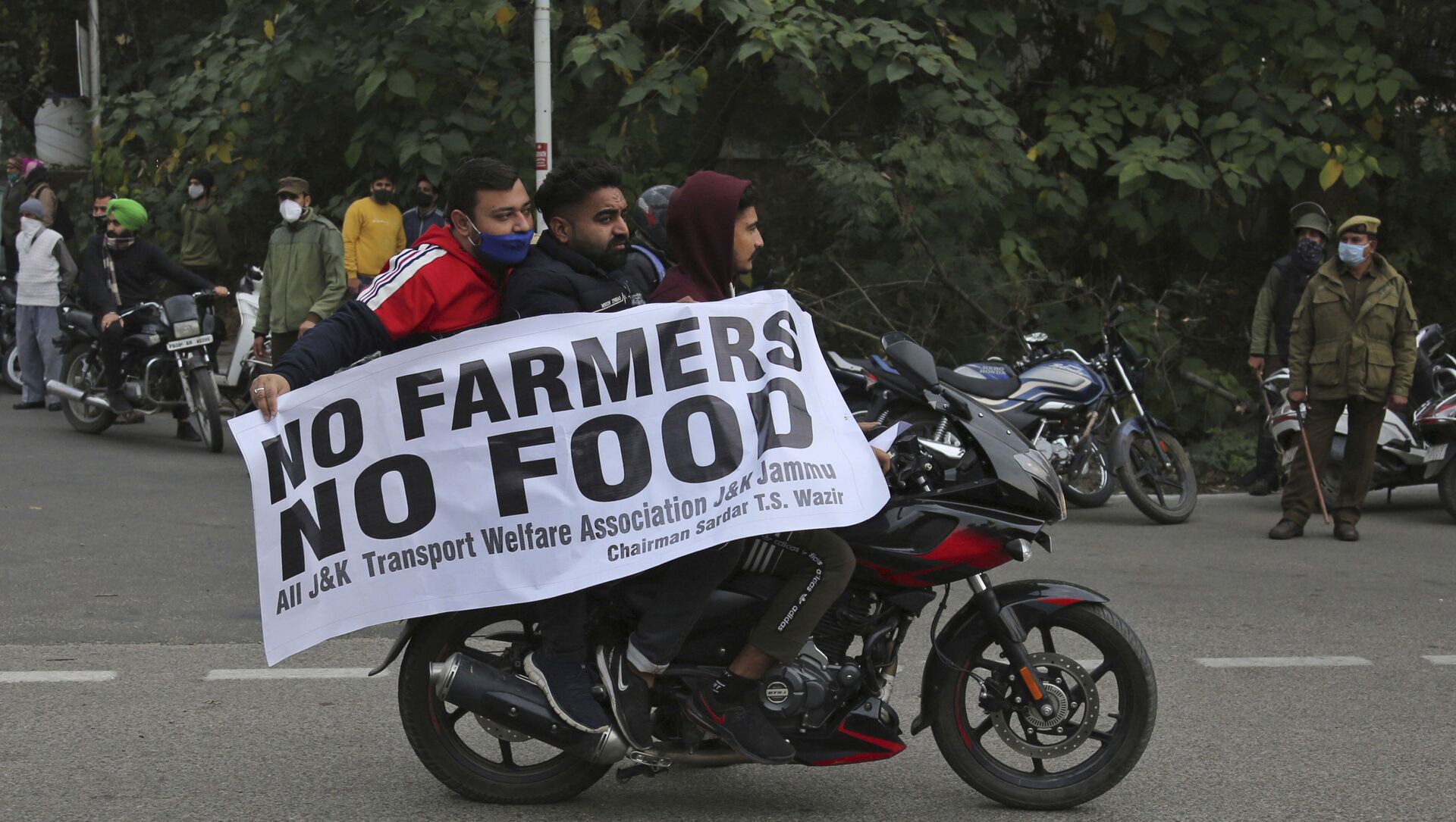 Protestors hold a placard and join others as they block the Jammu-Pathankot higway during a nationwide shutdown called by thousands of Indian farmers protesting new agriculture laws in Jammu India, Tuesday, Dec. 8, 2020 - Sputnik International, 1920, 15.02.2021