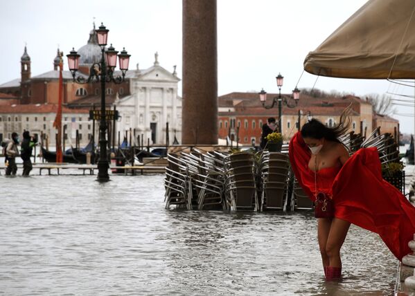A model holding her dress on flooded St. Mark's Square, Venice - Sputnik International