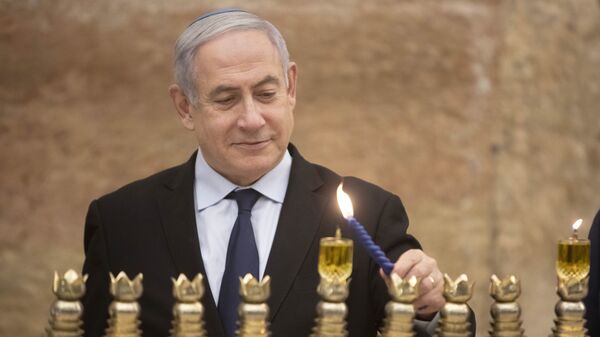Israeli Prime Minister Benjamin Netanyahu, lights a Hanukkah candle at the Western Wall, the holiest site where Jews can pray in Jerusalem's old city, Sunday, Dec. 22, 2019 - Sputnik International