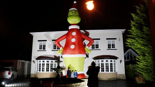 People pose in front of a giant inflatable character The Grinch outside a house, amid the outbreak of the coronavirus disease (COVID-19) in Hartlepool, Britan November 29, 2020. - Sputnik International