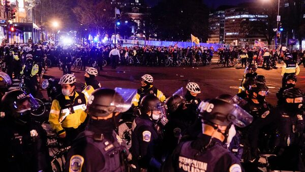 Police officers stand in formation to separate members of the Proud Boys group and counter protesters, in downtown Washington, U.S., 12 December 2020.  - Sputnik International