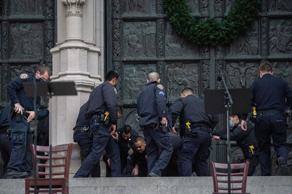 Police officers detain a man who opened fire outside the Cathedral Church of St. John the Divine in the Manhattan borough of New York City, New York, U.S., December 13, 2020  - Sputnik International