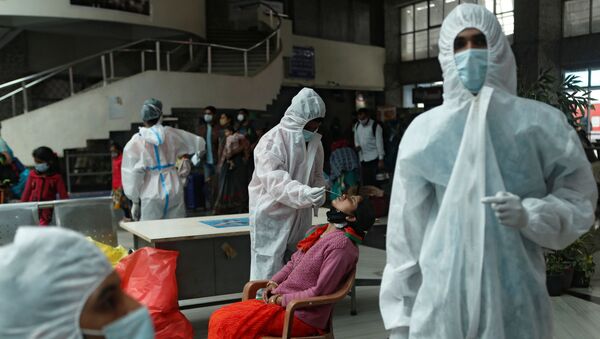 A health worker in personal protective equipment (PPE) collects a swab sample from a woman during a rapid antigen testing campaign for the coronavirus disease (COVID-19), at a railway station in Mumbai, India, December 11, 2020 - Sputnik International