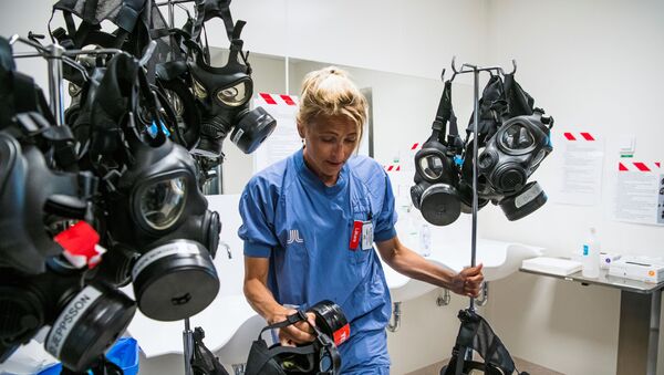 Karin Hildebrand, a doctor in an intensive care unit (ICU) in Stockholm's Sodersjukhuset hospital cleans and disinfects a protective face mask after treating patients with COVID-19 on June 11, 2020, during the coronavirus COVID-19 pandemic - Sputnik International