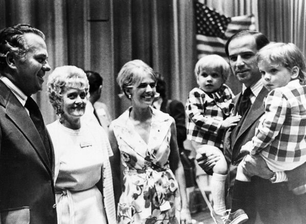 Sen. Joe Biden (D-Del.) carries both of his sons, Joseph R. III, left, and Robert H., during an appearance at the Democratic state convention last summer, 1972.  His wife Neilia Biden, centre, was killed in a car crash in 1972. With them are Governor-elect Sherman W. Tribbitt and his wife, Jeanne.  - Sputnik International