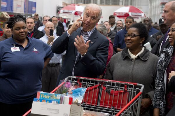 US Vice President Joe Biden talks on an employee's cellphone during a visit to a Costco store on a shopping trip in Washington DC on 29 November, 2012. - Sputnik International