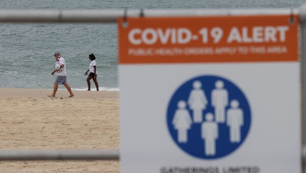 People walk by the ocean beyond a coronavirus disease (COVID-19) public health warning sign at Bondi Beach in Sydney, Australia, November 23, 2020 - Sputnik International