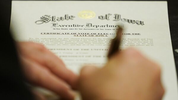 A member of Iowa's Electoral College signs the Certificate of Vote of Electors for the State of Iowa, Monday, Dec. 14, 2020, at the Statehouse in Des Moines, Iowa - Sputnik International