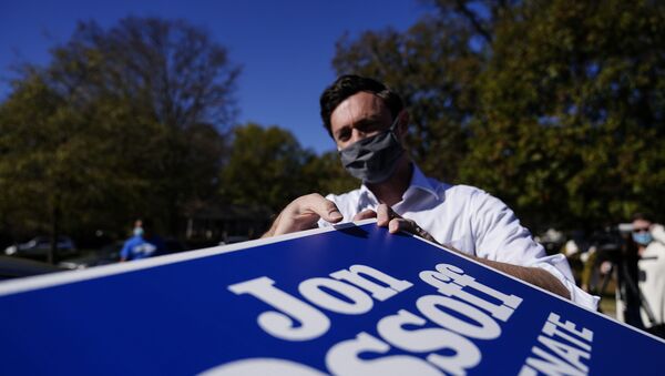 Georgia Democratic candidate for U.S. Senate Jon Ossoff grabs signs to give out during a drive-through yard sign pick-up event on Wednesday, Nov. 18, 2020, in Marietta, Ga. Ossoff and Republican candidate for Senate Sen. David Perdue are in a runoff election for the Senate seat.  - Sputnik International