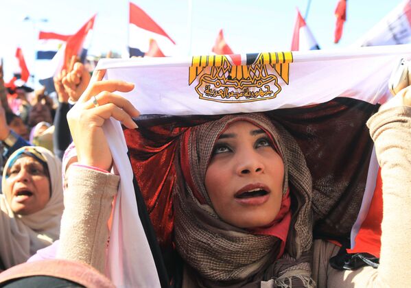 An Egyptian woman covers her head in a national flag as she demonstrates in Cairo's Tahrir Square on 27 January 2012 - Sputnik International