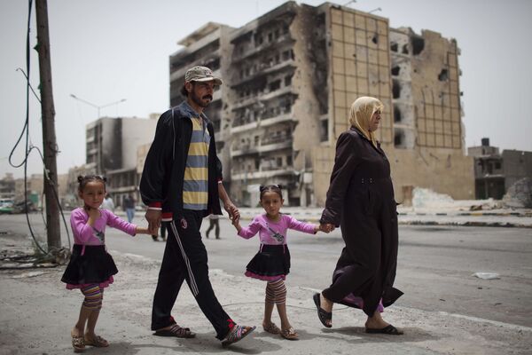 A family walks in Tripoli Street, the centre of the fighting between the rebels and Muammar Gaddafi’s forces in Misrata, Libya, Sunday, 22 May 2011 - Sputnik International