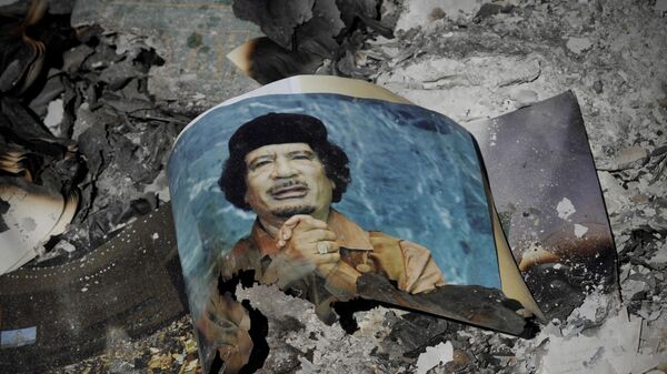 Picture of Libya's ousted leader Moammar Gadhafi is seen in the ashes in downtown Sirte, Libya, Wednesday, Oct. 12, 2011.  - Sputnik International