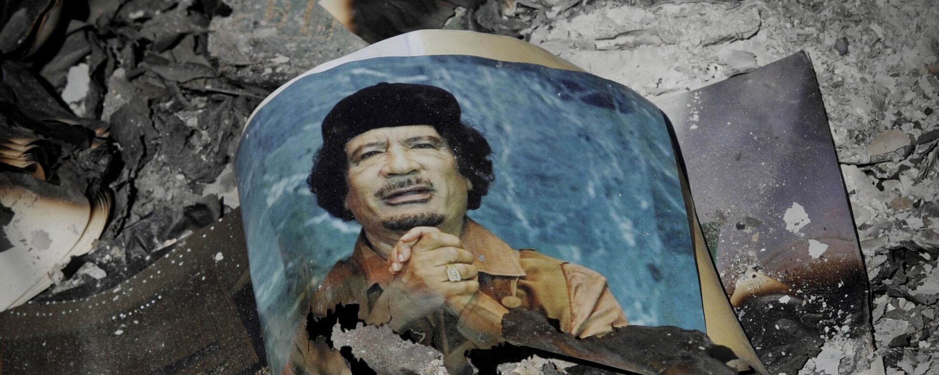 Picture of Libya's ousted leader Moammar Gadhafi is seen in the ashes in downtown Sirte, Libya, Wednesday, Oct. 12, 2011.  - Sputnik International, 1920, 18.03.2026