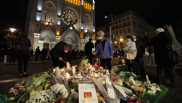 People light candles outside Notre-Dame de l'Assomption Basilica in Nice on October 31, 2020, to pay tribute to the victims two days after a knife attacker killed three people, cutting the throat of two, inside the church of the French Riviera city, and police arrest a young Tunisian migrant from Sfax who arrived in Europe only last month, according to French prosecutors.  - Sputnik International