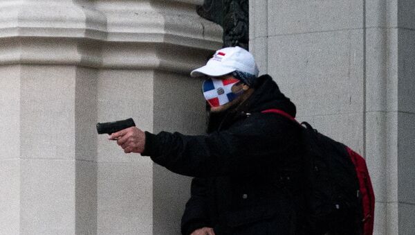 A man wearing a protective mask points his guns outside the Cathedral Church of St. John the Divine in the Manhattan borough of New York City, New York, U.S., December 13, 2020. - Sputnik International