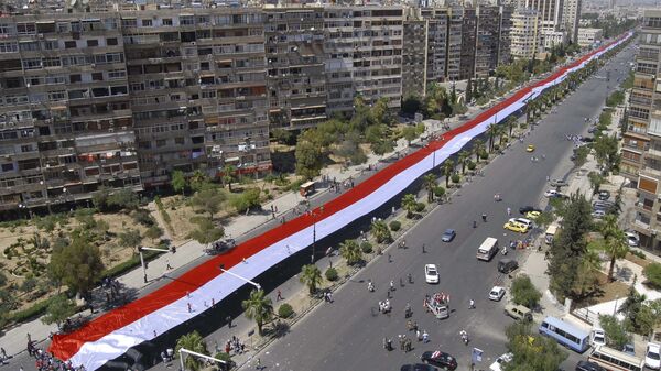 FILE -  In this June 15, 2011 file photo, thousands of supporter of Syrian President Bashar Assad, carry a gigantic 2,500 yard (2,300 meter) Syrian flag, as they march along a highway during a demonstration to support their president, in Damascus, Syria - Sputnik International