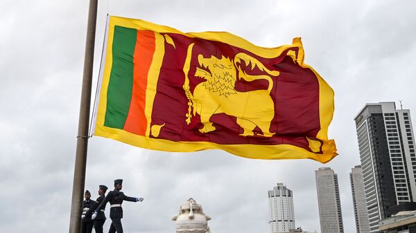 Soldiers stand at attention as the national flag is lowered as part of a daily ceremony at the Galle Face Green promenade in Colombo on May 17, 2020. - Sputnik International