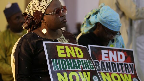 A demonstrator holds a sign during a protest to urge authorities to rescue hundreds of abducted schoolboys, in northwestern state of Katsina, Nigeria, December 17, 2020. - Sputnik International