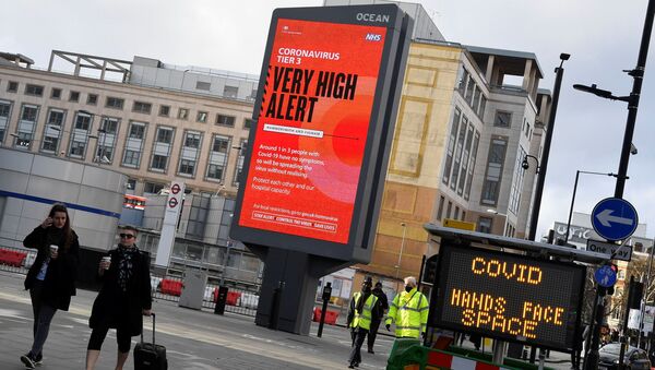 Pedestrians walk past a British government health information advertisement highlighting new restrictions amid the spread of the coronavirus disease (COVID-19), London, Britain - Sputnik International