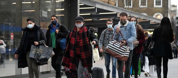 Travellers walk outside of King's Cross station as the British government imposes a stricter tiered set of restrictions amid the coronavirus disease (COVID-19) pandemic, in London, Britain, December 20, 2020 - Sputnik International
