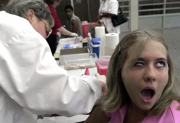 Michelle Krebs, 18,  reacts as she is vaccinated by school nurse Jill Kuhns,  Friday, 8 June, 2001 a Salem High School in Salem, Ohio.  - Sputnik International