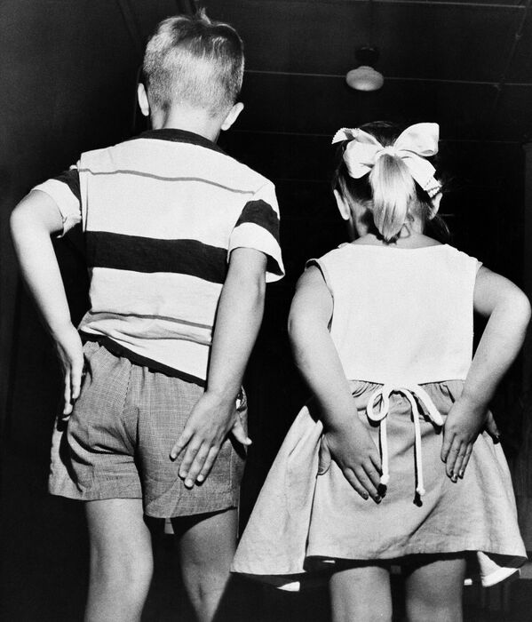 Coggie Pearce, left, and his sister, Debbie, 4, rub their behinds after receiving inoculations of gamma globulin in mass testing of the preventative polio vaccine, 2 July, 1952.  - Sputnik International