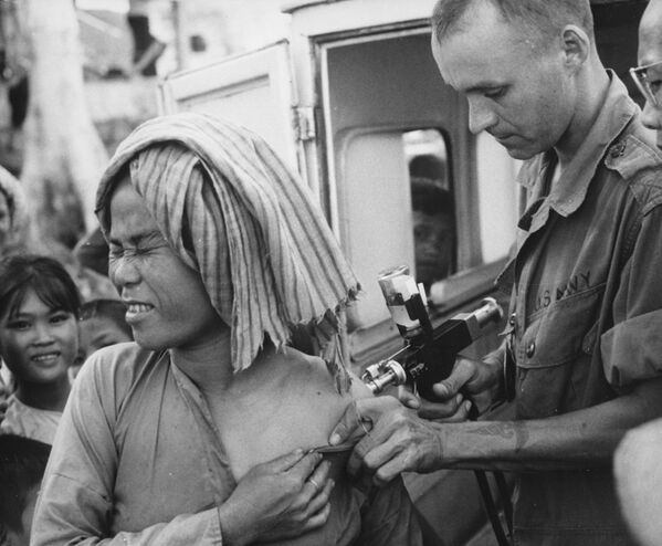 A U.S. Navy hospital corpsman, member of a USAID military health team, inoculates a flood refugee against cholera at the refugee centre on Nui Sam mountain, Chau Doc province., 1966 - Sputnik International