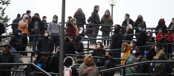 People wearing face masks queue to get tested for COVID-19 outside a private lab for clinical analysis in Madrid on December 21, 2020. - Sputnik International