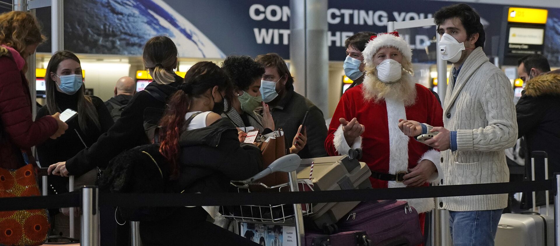 Турист в костюме Санта-Клауса в очереди в зале вылета терминала 2 аэропорта Хитроу в Лондоне, Великобритания - Sputnik International, 1920, 10.02.2021