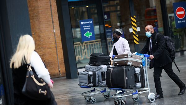 Travellers walk with their luggage at King's Cross station, as EU countries impose a travel ban from the UK following the coronavirus disease (COVID-19) outbreak, in London, Britain, December 21, 2020. - Sputnik International