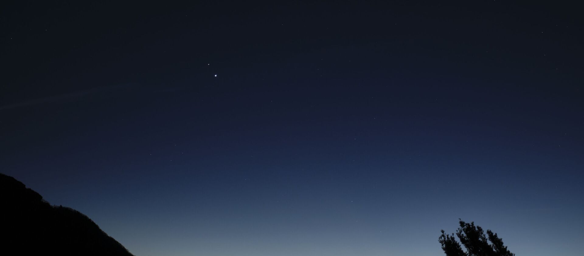 Saturn, top, and Jupiter, below, are seen after sunset from Shenandoah National Park, Sunday, Dec. 13, 2020, in Luray, Virginia. The two planets are drawing closer to each other in the sky as they head towards a “great conjunction” on December 21, where the two giant planets will appear a tenth of a degree apart. - Sputnik International, 1920, 11.02.2021