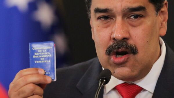 Venezuelan President Nicolas Maduro holds Venezuela's constitution as he speaks during a press conference following the ruling Socialist Party's victory in legislative elections that were boycotted by the opposition in Caracas, Venezuela December 8, 2020.  - Sputnik International