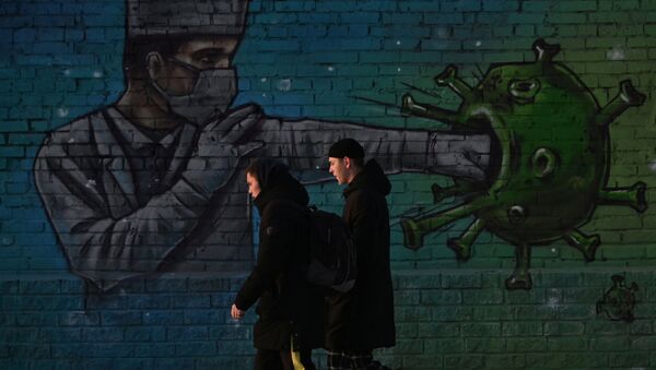 People walk past a graffiti depicting a healthcare worker fighting the virus, amid the outbreak of the coronavirus disease (COVID-19) in Omsk, Russia November 23, 2020 - Sputnik International