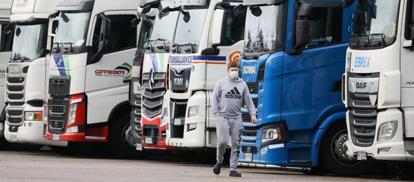 A driver wearing a face mask walks past lorries at Ashford International Truck Stop, as EU countries impose a travel ban from the UK following the coronavirus disease (COVID-19) outbreak, in Ashford, Britain 22 December 2020. - Sputnik International