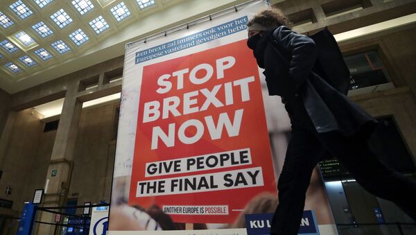 A woman walks past a billboard depicting a photo of a placard reading Stop Brexit Now at the Central railway station in Brussels, Belgium December 17, 2020.  REUTERS/Yves Herman - Sputnik International