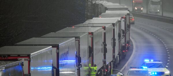 A police officer knocks on a cabin of one of lorries parked on the M20 motorway towards Eurotunnel and the Port of Dover, as EU countries impose a travel ban from the UK following the coronavirus disease (COVID-19) outbreak, in Folkestone, Britain, December 21, 2020.  - Sputnik International