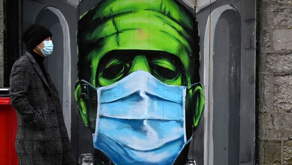 A man walks past a graffiti of a Frankenstein wearing a protective face mask on a doorway amid the spread of the coronavirus disease (COVID-19) pandemic, in Galway, Ireland, December 22, 2020 - Sputnik International