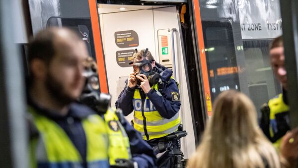 A Swedish police officer adjusts a protective mask at the border control point at Hyllie station, as the Swedish government shut the border after a mutated strain of the coronavirus was discovered in Denmark, in Malmo, Sweden December 22, 2020 - Sputnik International