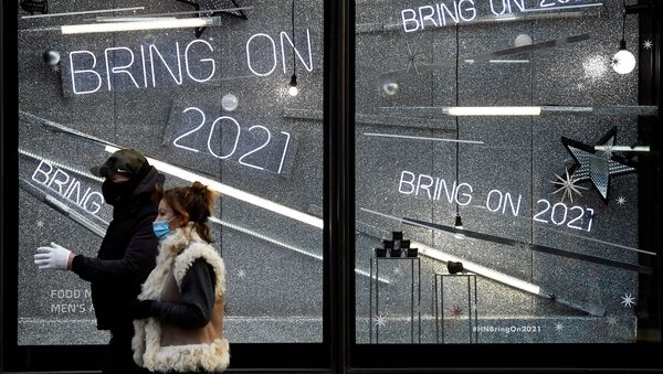 People wearing protective masks walk past a window display of a closed retail store as the British government imposes a stricter tiered set of restrictions amid the coronavirus disease (COVID-19) pandemic, in London, Britain, 20 December 2020 - Sputnik International