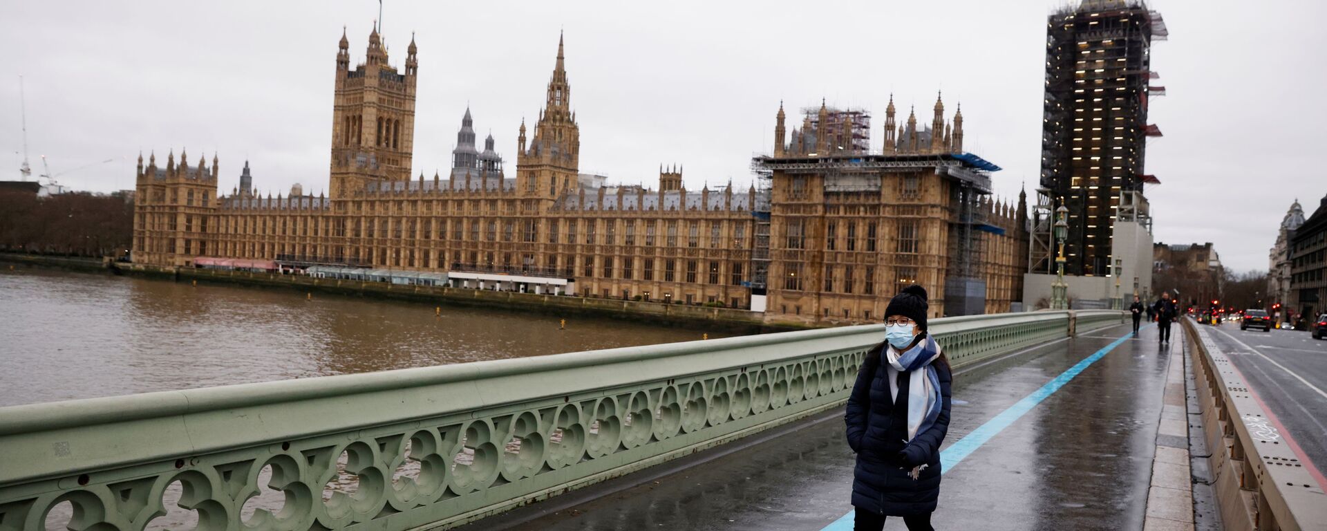 A woman wearing a face mask walks across Westminster Bridge past the Houses of Parliament, as the spread of the coronavirus disease (COVID-19) continues, in London, Britain, December 22, 2020 - Sputnik International, 1920, 30.12.2020