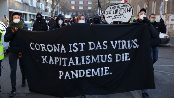 People supporting the government's restrictions hold a banner reading: Corona is the virus, capitalism is the pandemic, following the coronavirus disease (COVID-19) outbreak, in Berlin, Germany, December 30, 2020 - Sputnik International