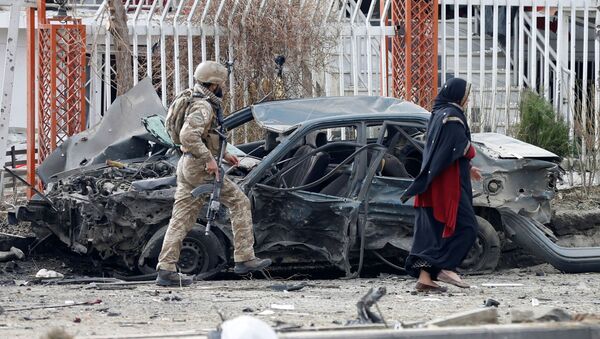 A member of Afghan security forces inspects a damaged vehicle at the site of a blast in Kabul, Afghanistan December 20, 2020.  - Sputnik International