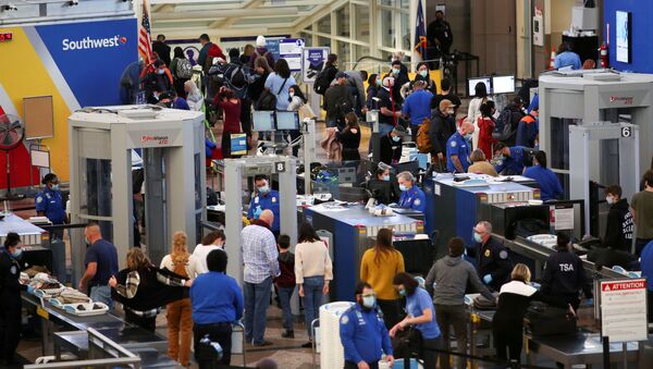 Travelers wearing protective face masks to prevent the spread of the coronavirus disease (COVID-19) go through security before boarding a flight at the airport in Denver, Colorado, U.S., November 24, 2020.  - Sputnik International