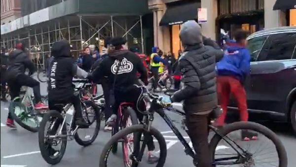 A group of teenagers on bicycles blocks traffic and attacks an SUV at the intersection of East 21st Street and Fifth Avenue in the Manhattan borough of New York City on Tuesday 29 December 2020. - Sputnik International