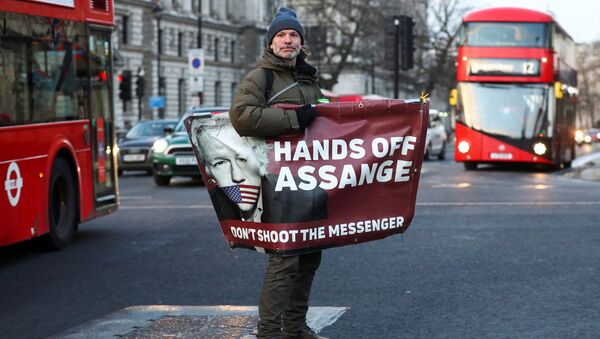 A man rides a skateboard holding a banner with an image of Julian Assange in London, Britain, December 30, 2020 - Sputnik International